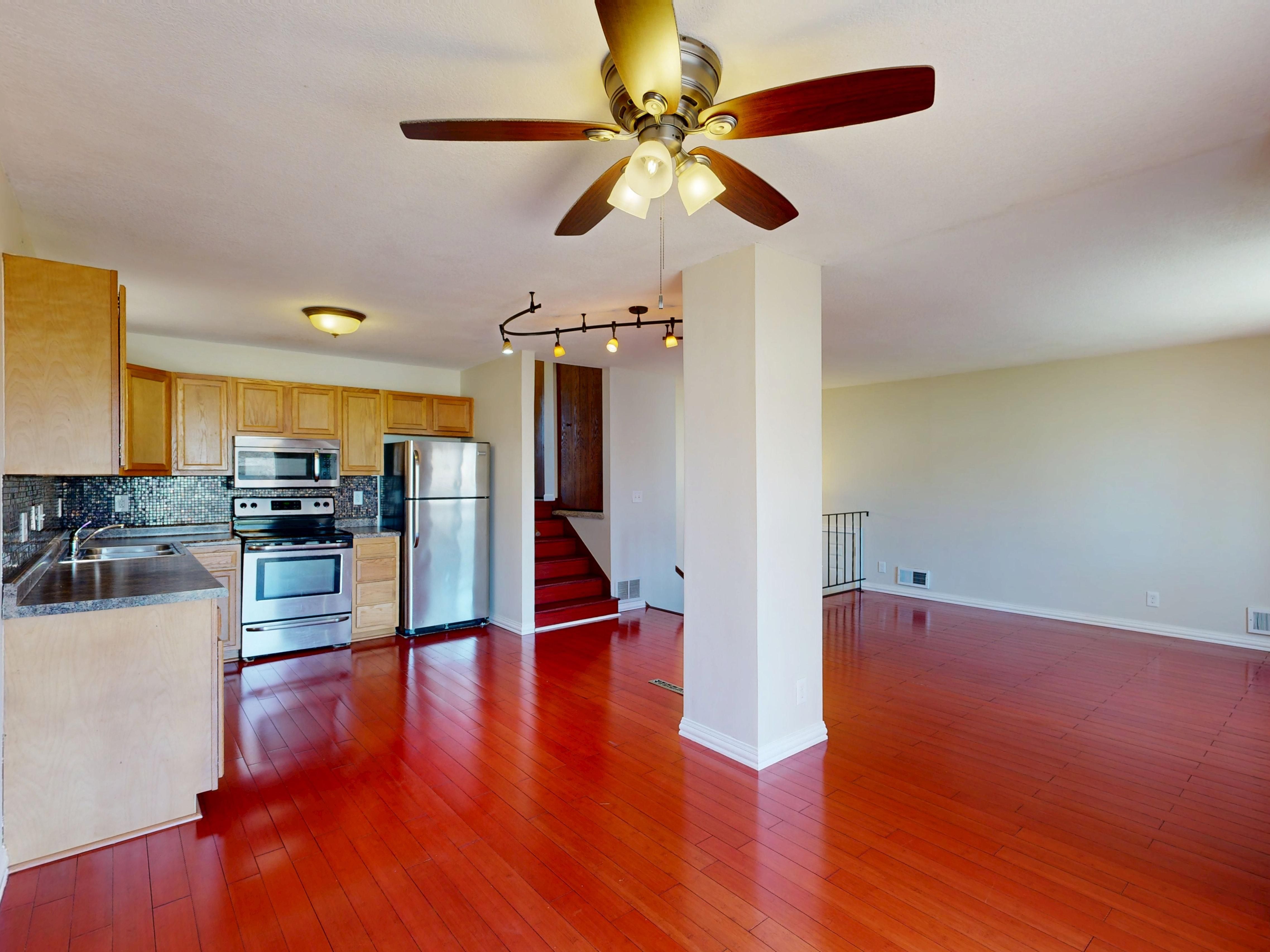 Spacious open-concept Devore CA rental interior with red hardwood floors and a full kitchen